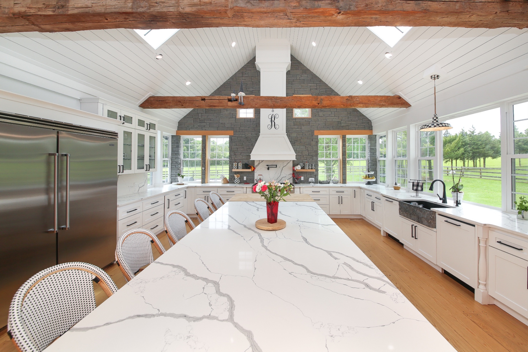 Marble waterfall island and farmhouse sink in a luxury custom kitchen remodel