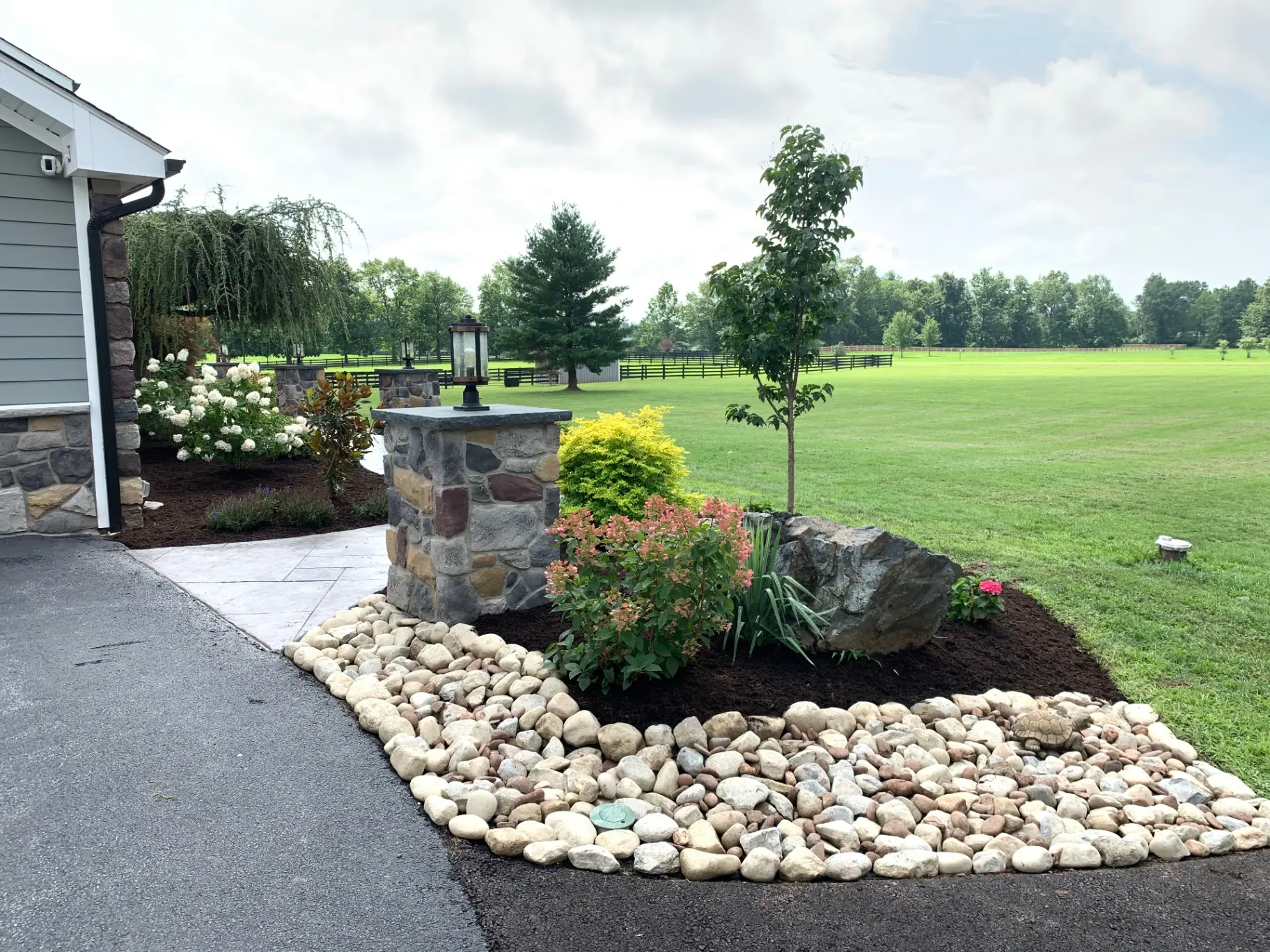 Eldorado Stone masonry pillar with a flat cap and post lantern beside a stamped concrete walkway in Buckingham, PA